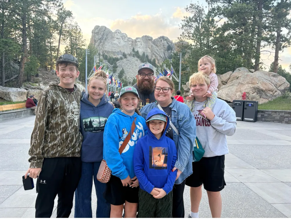 Pastor Allen Nelson with his wife Stephanie and their six children in front of Mount Rushmore.